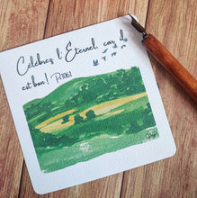 Charger l'image dans la galerie, Carte carrée aquarelle représentant une colline verdoyante dans une vallée paisible avec des oiseaux s'envolant dans un ciel illuminé par un soleil radieux. Le verset biblique Psaume 106:1 "Louez l'Éternel, car il est bon !" est inscrit sur la carte.