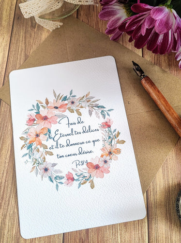 Carte postale aquarelle représentant une couronne de fleurs dans des tons doux de rose saumon pâle et de blanc, avec des petites branches de gypsophile rehaussées d'argent pailleté. Le verset biblique Psaume 37:4 