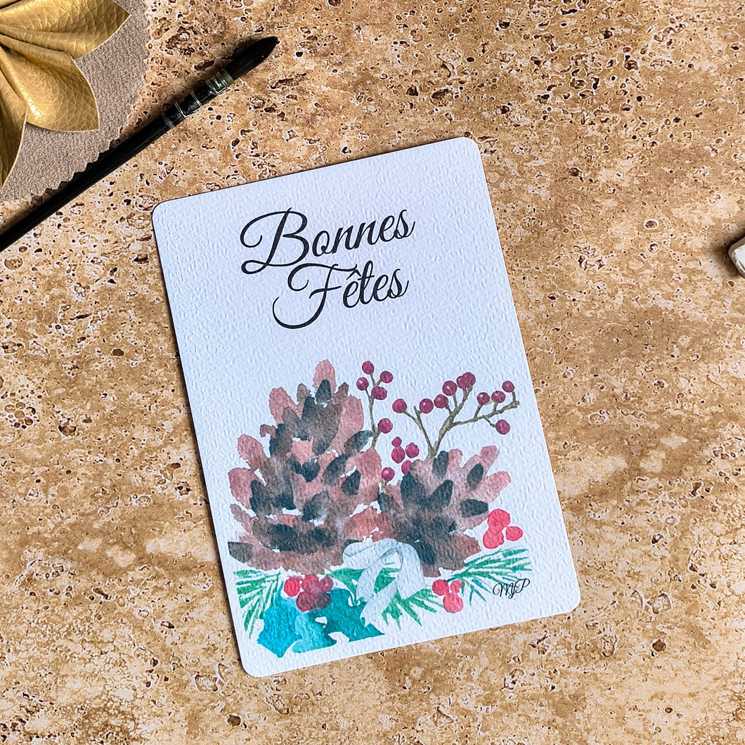 Carte de voeux peinte à l'aquarelle représentant des pommes de pin, houx et branches